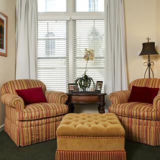 Cozy living room with armchairs and an ottoman by the window.