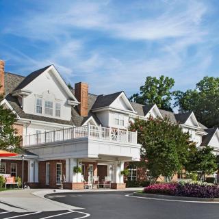 A beautiful residential building with lush landscaping under a clear blue sky.