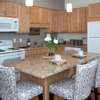 A modern kitchen featuring a central island with patterned stools and contemporary appliances.