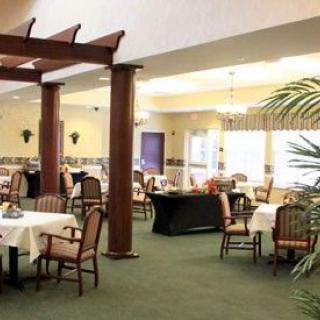 A spacious dining area with neatly arranged tables and chairs under warm lighting.