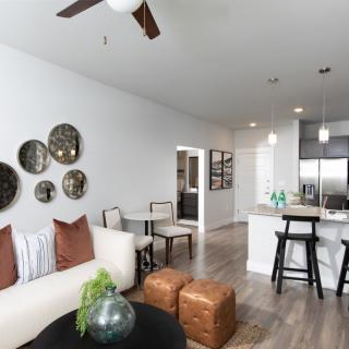 A modern open-concept living and kitchen area with stylish decor and neutral tones.
