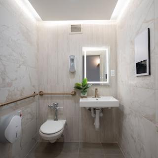 A sleek and modern bathroom featuring a compact sink, toilet, and minimal decor.