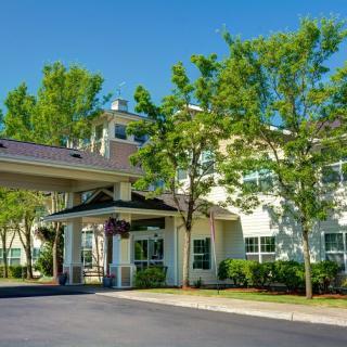 A hotel entrance surrounded by trees on a sunny day.