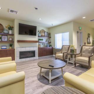 A cozy living room with comfortable seating, a fireplace, and a television.