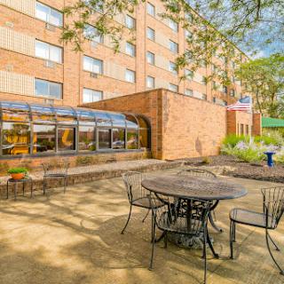 A serene outdoor seating area next to a brick building, perfect for relaxation.