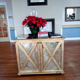 A beautifully arranged table with a bouquet of red poinsettias in a cozy interior space.