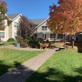 A picturesque view of a building surrounded by autumn trees and a garden pathway.
