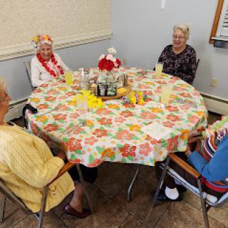 A cheerful gathering of seniors around a beautifully decorated table, enjoying each other's company.
