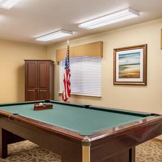 A billiards room featuring a pool table, an American flag, and framed artwork on the wall.