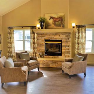 Cozy living room with a central stone fireplace and comfortable seating.