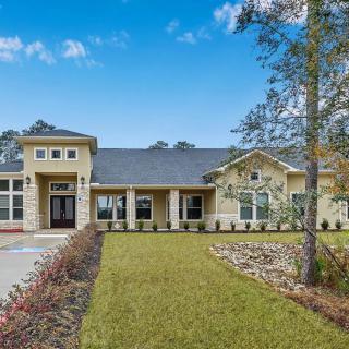 A modern residential house with a neatly maintained lawn and surrounding trees.