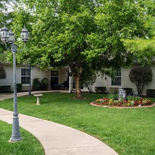 A well-maintained garden with a winding pathway and lush green surroundings.
