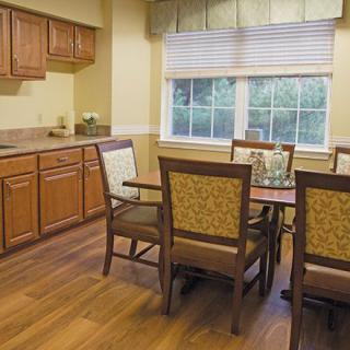 A cozy dining area with wooden furniture and a large window.