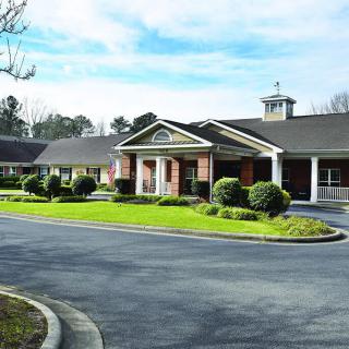 A suburban building with a circular driveway and well-maintained landscaping.