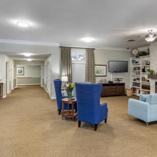 A comfortable lounge area with blue armchairs and a television.
