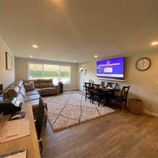 A cozy living room featuring comfortable sofas, a dining area, and a wall-mounted TV.