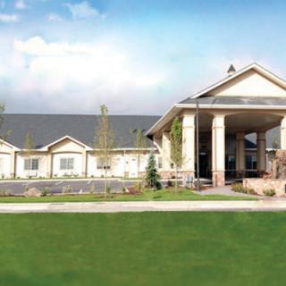 A large building with a grand entrance and well-maintained lawn.