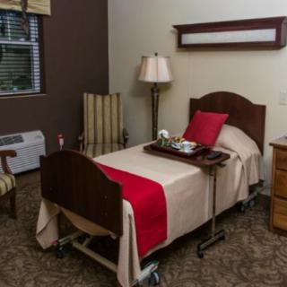 A cozy bedroom with a single bed, tray, and seating area.