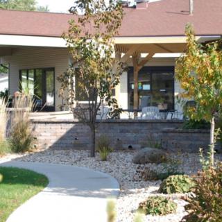 A modern house with a landscaped yard and a pathway leading to the entrance.
