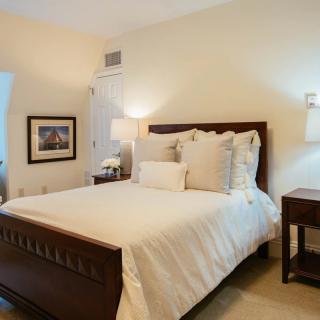 A cozy and well-decorated bedroom with a neatly made bed and warm lighting.