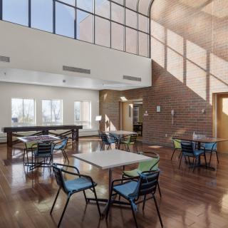 A modern dining area with large windows and ample natural light.