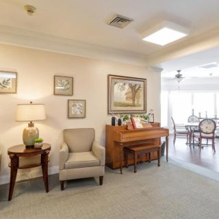A cozy living room with a piano and elegant furnishings.