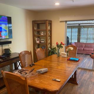 A cozy dining and living area with a wooden table, chairs, and a television.