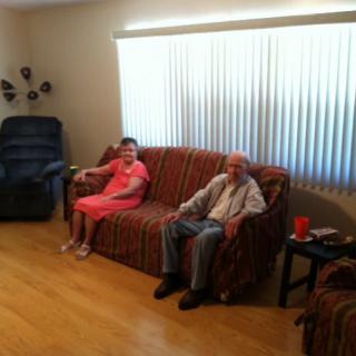 Two people sitting on a couch in a living room.