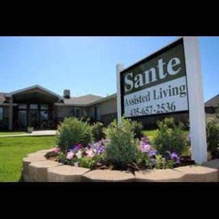 A well-maintained assisted living facility with a prominent sign and landscaped garden.