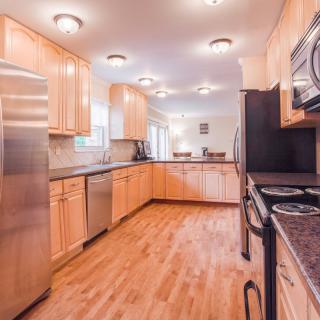 A modern kitchen with stainless steel appliances and wood flooring.
