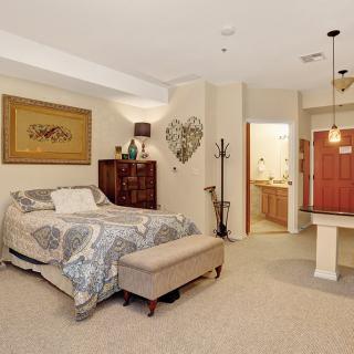 A cozy bedroom featuring a comfortable bed, decorative wall art, and stylish lighting.