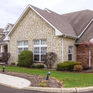 A suburban house with a brick facade and well-maintained landscaping.