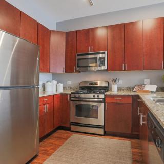 A modern kitchen with wooden cabinets and stainless steel appliances.