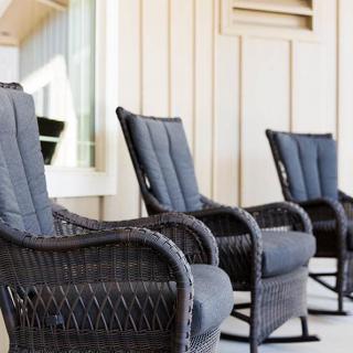 A row of wicker chairs on a sunny porch, perfect for relaxation.