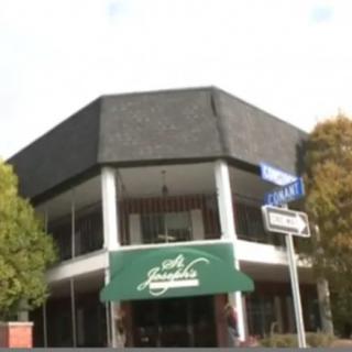 A hexagonal building with a green awning, likely housing a restaurant.