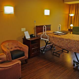 A cozy treatment room featuring a massage table, comfortable seating, and warm lighting.