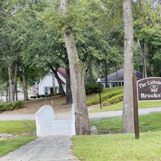 A peaceful park scene with a walkway surrounded by trees and a sign.