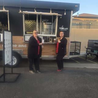 Two customers enjoying their experience at a food truck.