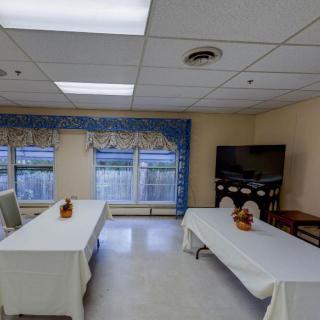 A well-lit meeting room with tables and a television arranged for a gathering.