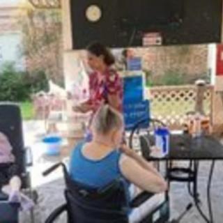 An outdoor gathering with people socializing, including individuals in wheelchairs.
