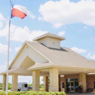 A welcoming building in Texas with the state flag waving proudly against a bright sky.