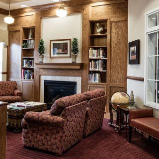 Cozy living room with a fireplace, bookshelves, and comfortable seating.