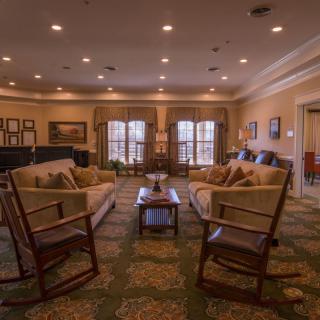Cozy living room with sofas and chairs arranged around a central coffee table.