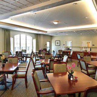 A spacious dining area with neatly arranged tables and chairs, complemented by soft lighting.