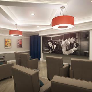 A modern home theater room with comfortable seating and stylish lighting, featuring a large projector screen and classic movie artwork on the walls.
