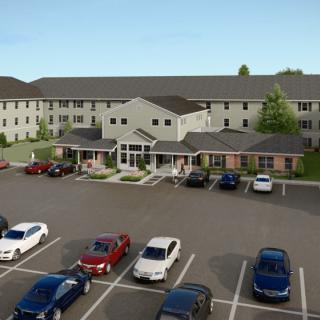 A residential building with a parking lot filled with various vehicles.