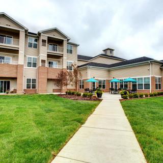 A modern residential apartment complex with manicured lawns and balconies.
