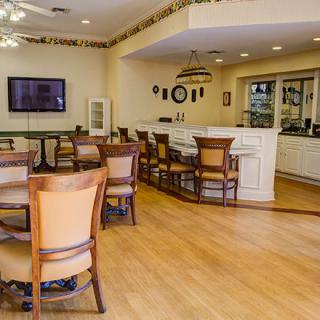 A dining area with wooden floors, tables, and chairs in a cozy restaurant setting.