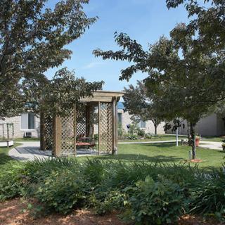 A serene park scene featuring a gazebo surrounded by lush greenery.