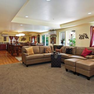 Spacious open living room with a cozy sectional sofa, adjacent dining area, and kitchen.